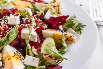 Fresh mixed salad in a bowl on a white background