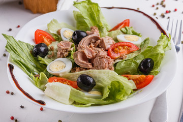 Fresh salad with iceberg lettuce,tomatoes,eggs,canned tuna and olives