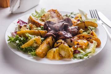 Baked potatoes with boiled chicken liver on a plate