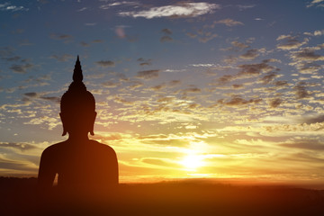 Silhouette statue of Buddha at sunset background