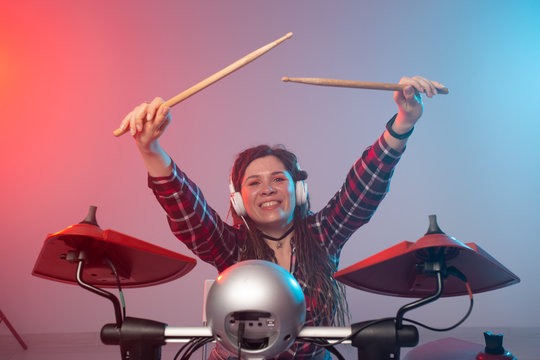 Music and hobby concept - woman drummer playing the electronic drum set