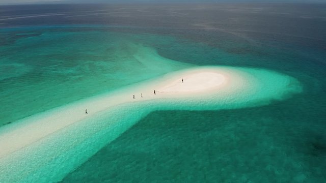 Aerial drone view orbiting a beautiful sand spit on a remote tropical island
