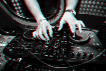 music remote for information and mixing music in nightclub with DJ hands closeup