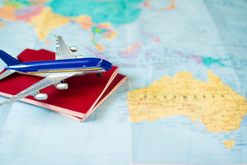  toy aircraft and two neutral passports on the world map. travel and air transportation concept, flight to australia, trip by plane, booking flights