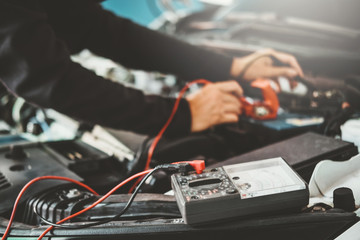 Naklejka premium Technician Hands of car mechanic working in auto repair Service and Maintenance car battery