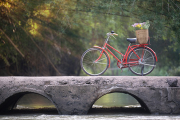 Old red bicycle on old bridge