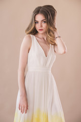 Beautiful woman portrait in elegant dress on beige background
