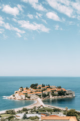 Atmospheric tourist views of the old town from the mountain. The picturesque coast of the island of Sveti Stefan.