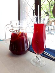 A delicious red cocktail stands at the window in the decanter