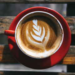 Top view cup of hot coffee or cappuccino is placed on an outdoor wooden table in the morning. Warm festival with warm drinks in the winter.