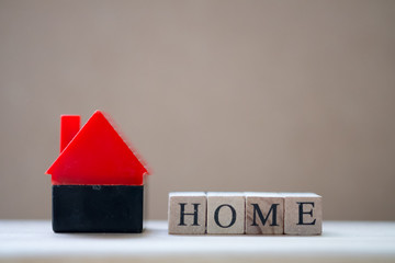 Wooden blocks with the word HOME stands near the house
