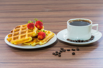 Viennese waffles with strawberries and a cup of coffee.