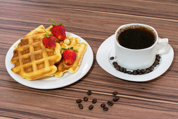 Viennese waffles with strawberries and a cup of coffee.