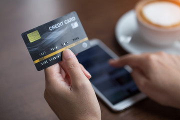 Hand holding credit card with shopping online. Online payment concept.