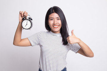 Young Asian woman show thumbs up with a clock.