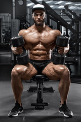 Fototapeta na wymiar Muscular man with dumbbells workout in gym, strong male naked torso abs