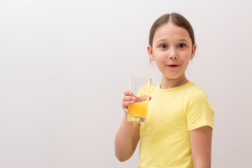 little girl drinks orange juice, a child enjoys a drink