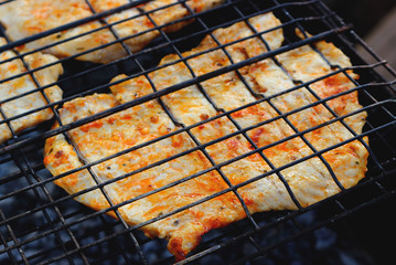 Grilled marinated pork entrecote cooking on grill. Concept background for a family summer picnic or dinner outdoor. Selective focus, top view