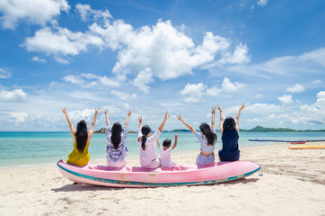 group of travel women with children sit on the boat on the beach with clear water and blue sky are happy and enjoy friendship hands up together fun on vacation day freedom.