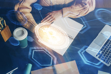 Cryptocurrency hologram over hands taking notes background. Concept of blockchain. Multi exposure