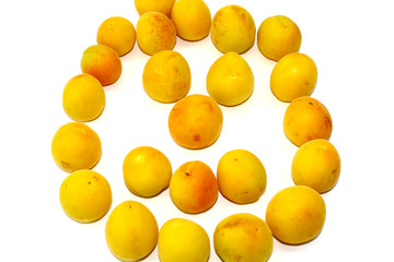 Small yellow apricots on white background