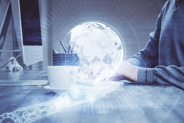 Double exposure of world map hologram with man working on computer on background. Concept of worldwideweb.