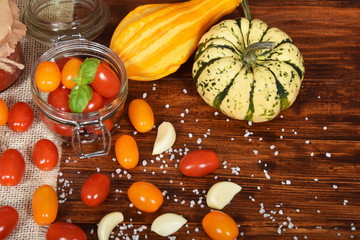 cocktail tomatoes, garlic, spices, colorful pumpkins and scattered kitchen salt