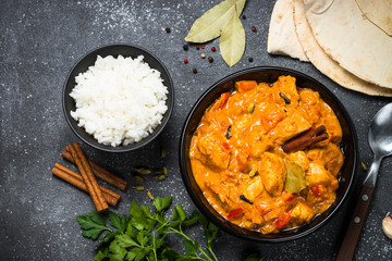 Chicken tikka masala with rice on black top view.