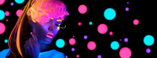 Fashion disco woman. Dancing model in neon light, portrait of beauty girl with fluorescent makeup....