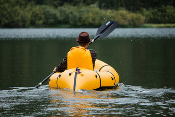 Rear view of kayaker man paddle kayak at sunset sea. Kayaking, canoeing, paddling