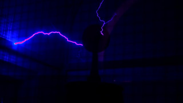 This video shows an antique tesla coil discharging lightning and giant sparks on a black background