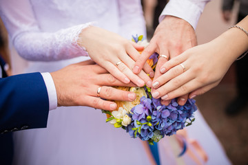 Obraz na płótnie Canvas rings on a wedding bouquet. close-up of the hand of the bride and groom with engagement rings and bouquet