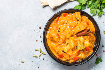 Chicken tikka masala with rice on black top view.