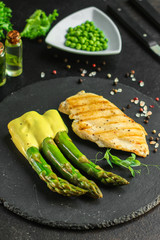asparagus and chicken grill meat, hollandaise sauce (slate plate). food background. top