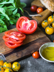 Various fresh ingredients for making sandwiches - vegetables, bread, olive oil and curd cheese on dark background
