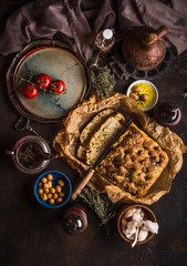 Traditional Italian focaccia bread to lunch, dinner or snack on rustic table with knife olives and...