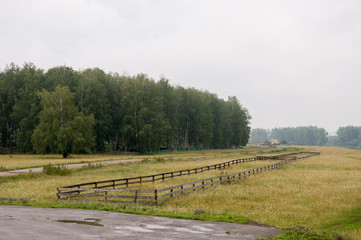 Heavy grey clouds in the cold autumn sky over  village. Old local farm and low fences in the mountains and fields. Travelling on the suburb roads. Cows and sheep are pasturing 
