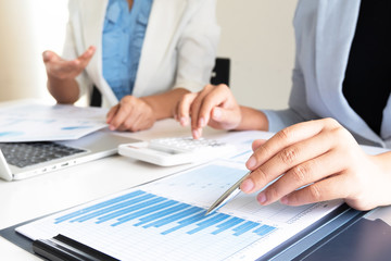 Two bussiness leader women discussing the charts and graphs showing the results