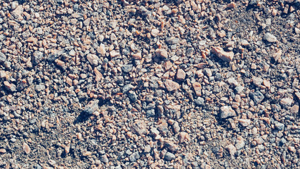 The soil under your feet with small stones with a textured surface. Texture or background.