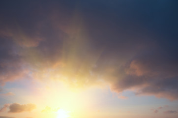 The setting sun against the background of rain clouds.