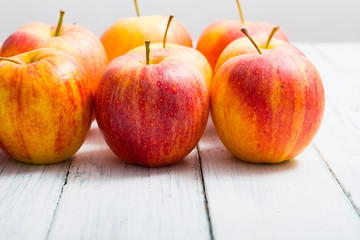 apple fruits in a row, white wooden table background
