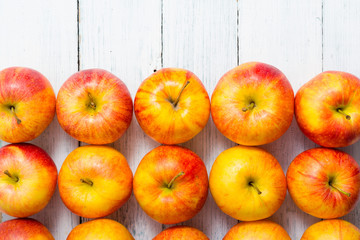 apple fruits in a row, white wooden table background