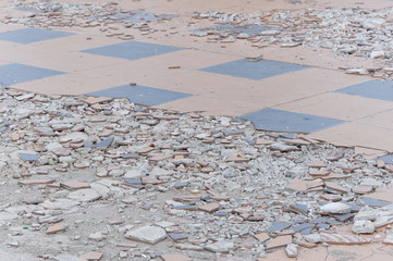 Sidewalk under repair works background with broken tiles, crushed fragments and construction...