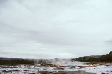 Stages of the eruption of the famous Strokkur Geyser In Iceland on a cold cloudy afternoon. Giant blue bubble right before the eruption