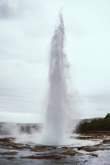 The eruption of the famous Strokkur Geyser In Iceland on a cold cloudy afternoon