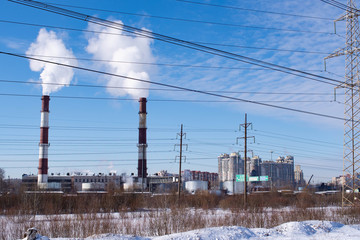 behind snowdrifts high pipes let off steam into the blue sky