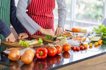 Young loving couple cooking and help each other while preparing rolling Rice Paper to vegetables.healthy Asian food