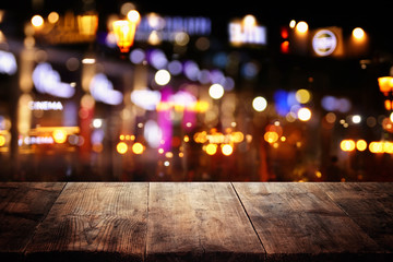 background of wooden table in front of abstract blurred restaurant lights