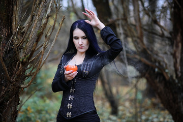 A woman in a witch suit in a forest
