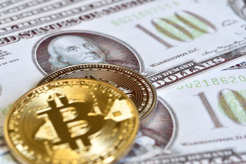 gold bitcoin on hundred dollars bills. close-up, macro, selective focusing.